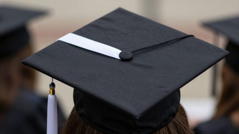 Graduation cap with white ribbon against gun violence.